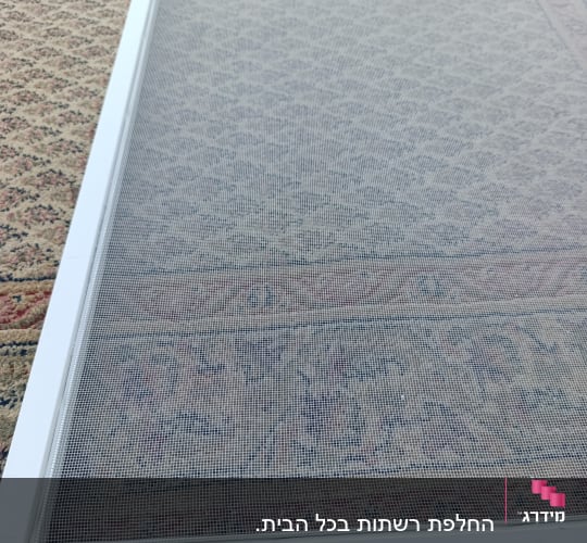 רשת אלומיניום לבנה לחלון מונחת לפני התקנה